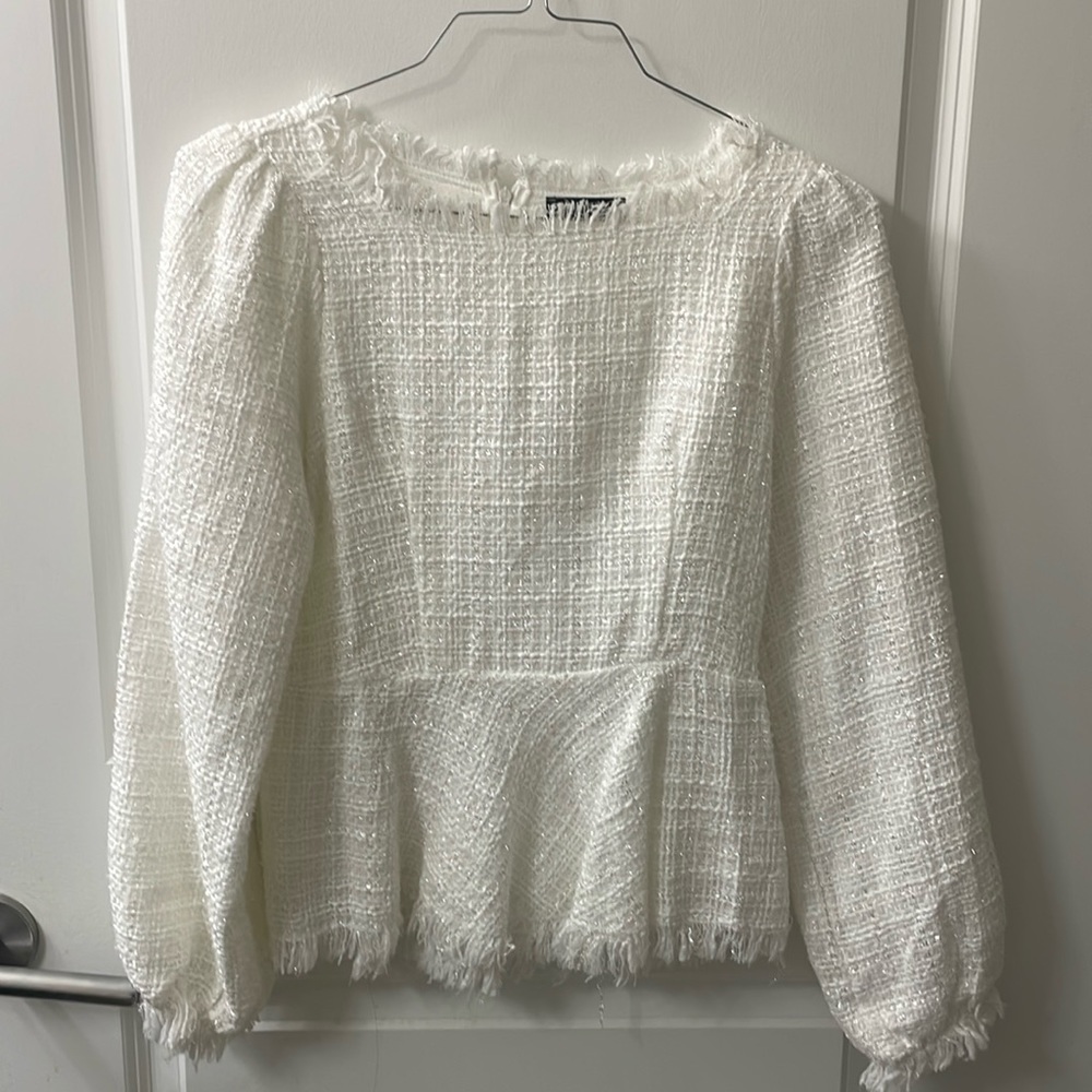 White peplum long sleeve top with sparkle detail.